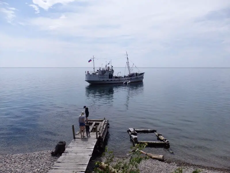 Boat on the still waters of Lake Baikal, at Listvyanka. Siberia, Russia.